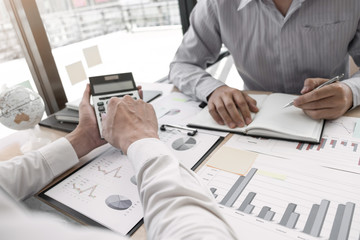 Two business people  are discussing about business graph on the table in the office room
