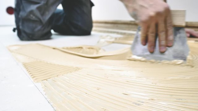 Handwerker verlegt holzboden Parkett in einem modernem haus. 4k Video in zeitlupe