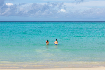 Fototapeta na wymiar Couple swimming in turquoise lagoon