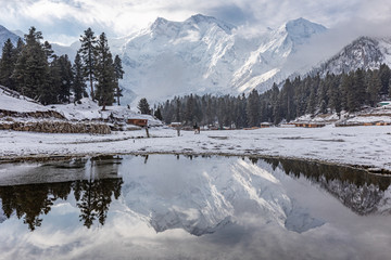 Fototapeta na wymiar Nanga parbat mountain reflection in lake on Fairy meadows valley beautiful winter snowy landscape Karakoram Pakistan