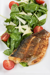 Grilled Dorado fish fillet with spinach, tomato and cheese