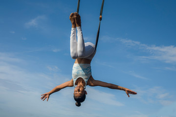 outdoors portrait of young happy and athletic Asian Indonesian woman doing aero yoga workout...