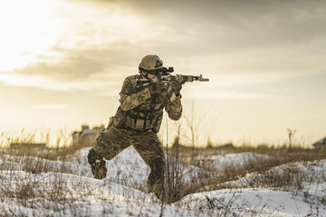 equipped army soldier Man in the winter khaki camouflage is patrolling or patrol field territory....