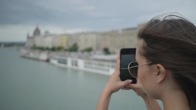 Girl making city photos from the bridge. Budapest, Hungary