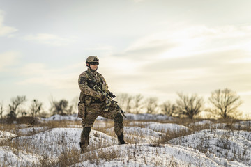 equipped army soldier Man in the winter khaki camouflage is patrolling or patrol field territory....