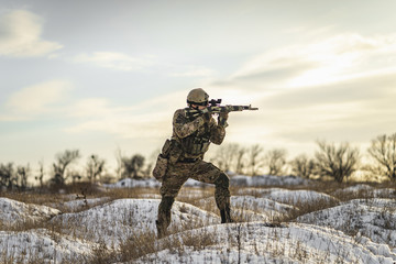equipped army soldier Man in the winter khaki camouflage is patrolling or patrol field territory....