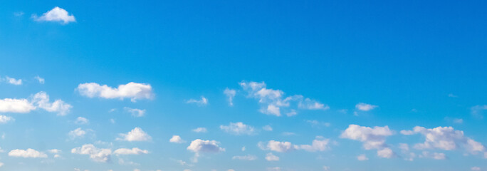 Fototapeta na wymiar White curly small clouds on blue sky background_