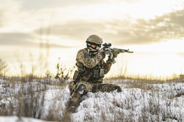 equipped army soldier Man in the winter khaki camouflage is patrolling or patrol field territory....