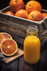 Fresh squeezed orange juice in a bottle on an old wooden table
