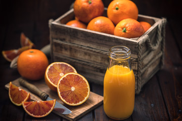 Fresh squeezed orange juice in a bottle on an old wooden table