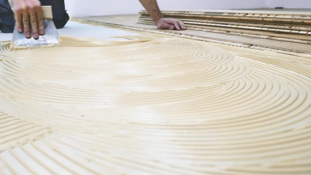 Handwerker verlegt holzboden Parkett in einem modernem haus. 4k Video in zeitlupe