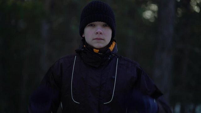 Portrait of teenager in a winter pine forest.