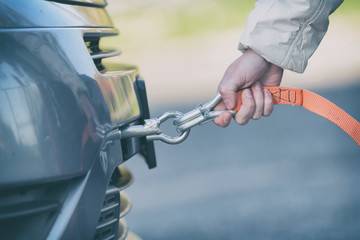woman assembling towing hook to a broken car