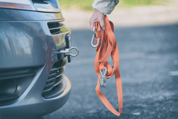 woman assembling towing hook to a broken car