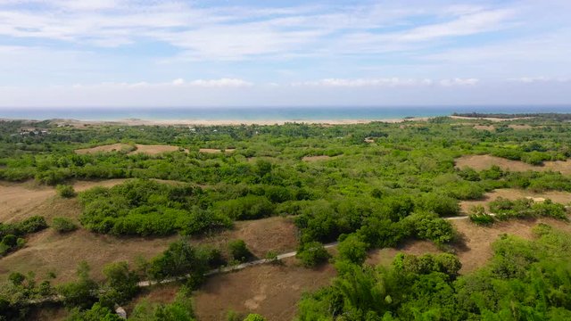 Sand Dunes of Paoay, Ilocos norte, Philippines. Landscape with tropical trees and the ocean in the distance, aerial view. 