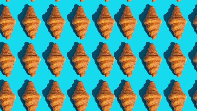 flat lay of croissants motion pattern on a color background