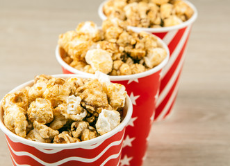 three red cardboard cup in a row with sugar popcorn