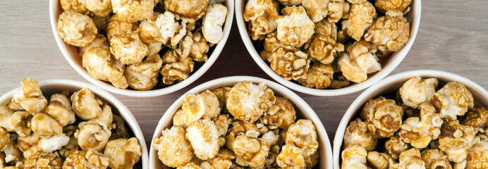 many red cardboard cup with sugar popcorn on a wooden table