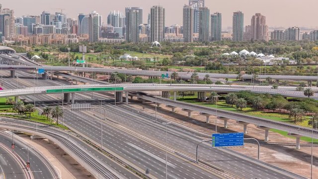 Dubai Golf Course with a cityscape of Gereens and tecom districts at the background aerial timelapse. Traffic on sheikh zayed road with junction