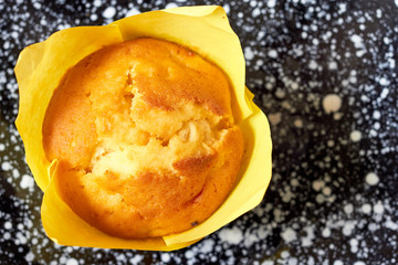 Muffin cupcake on black plate. Top view