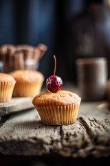 Muffins - sweet homemade cakes on a wooden kitchen table.