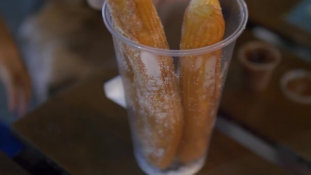 man dunks churros in sauce