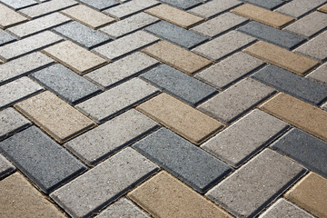 Background - colorful cobblestone pavement of the new paving stones. Diminishing perspective. Backlight.