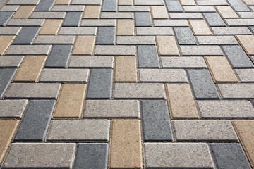 Fototapeta premium Background - colorful cobblestone pavement of the new paving stones. Diminishing perspective. Backlight.