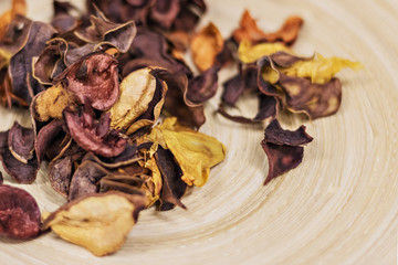Beautiful multi-colored dry flower petals for decor on a wooden background