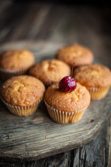 Muffins - sweet homemade cakes on a wooden kitchen table.