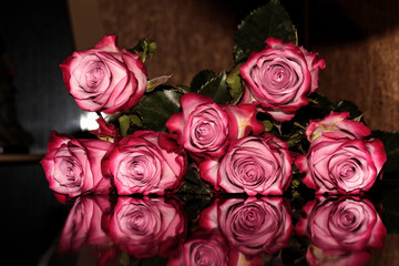 Roses reflected on the surface. Mirroring colors.