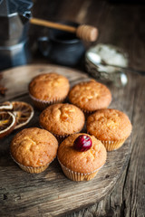 Muffins - sweet homemade cakes on a wooden kitchen table.