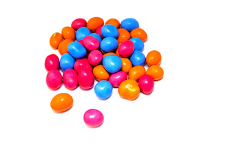 Pile of many multi-colored pea candies of blue, red and orange colors isolated on a white background. Sweet background.