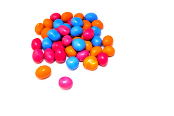 Pile of many multi-colored pea candies of blue, red and orange colors isolated on a white background. Sweet background.