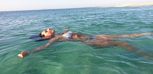 Woman floating on water in the sea