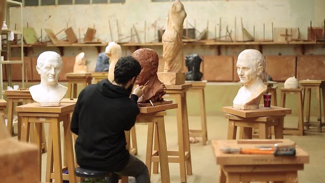 Sculptor finishing his bust of cicero clay in an art studio
