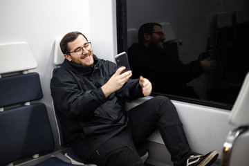 Smiling young adult with his smartphone making a video call or selfie