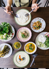 Top view of Rice Noodles with Crab Meat Curry Sauce, Served with vegetables. Stir Fried Spicy Minced Pork with Herbs. Spicy Crispy Pork Skin and Mushroom Soup. Classic Thai cuisine with steam rice.