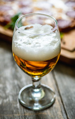 Freshly brewed beer and pepperoni pizza in bar. Selective focus. Shallow depth of field.
