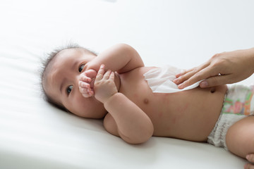 Obraz premium Mom cleaning up and wipe body baby by wet tissue when changing nappies or diaper and wiping the hands or face or leg, Personal hygiene for mother and Toddler kid with wet wipes paper concept