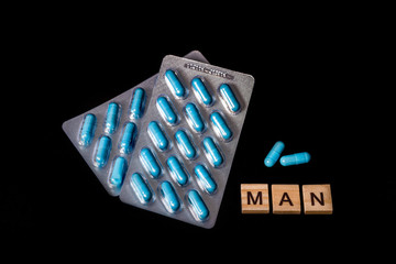 Two packs of blue capsules and inscription Man. Pills for men's health and sexual energy. Concept...