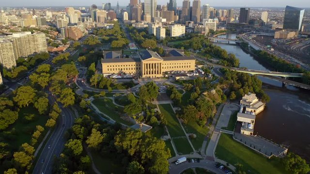Aerial drone reveal of Philadelphia skyline and Art Museum along Ben Franklin Parkway during a warm summer sunset