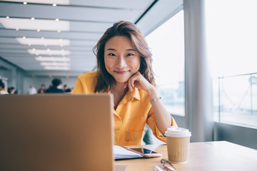 Female freelancer at workplace smiling and looking at camera