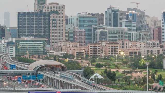 Dubai Golf Course with a cityscape of Gereens and tecom districts at the background aerial day to night transition timelapse. Traffic on sheikh zayed road with metro station