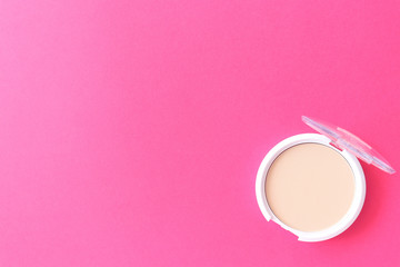 Beige powder for make-up, pink. Beautiful beige powder for make-up on a pink flat lay. Concept for your design. Spring background.