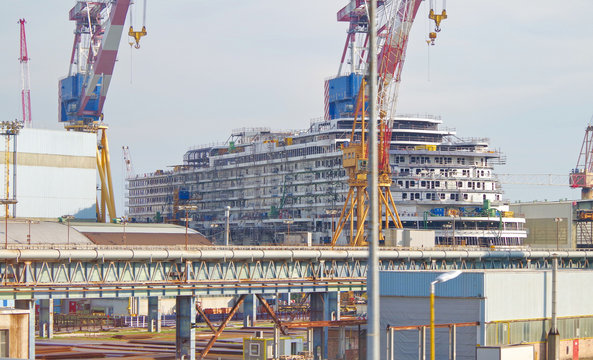Modern cruise ship liner or cruiseship being built by Italian Fincantieri shipyard in Venice with dock and cranes