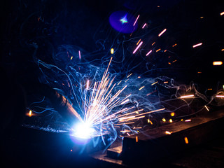 The process of welding metal in the dark with the formation of a large amount of smoke and sparks.