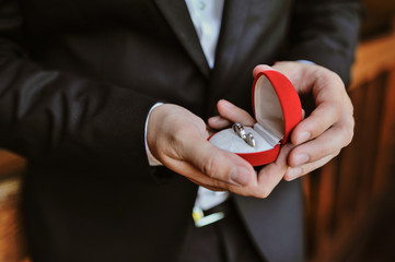 Groom holds wedding rings in his hands.Wedding rings in the hands of the groom.