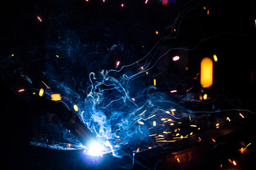 The process of welding metal in the dark with the formation of a large amount of smoke and sparks.