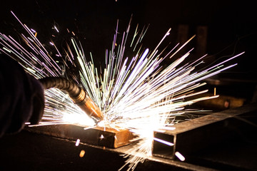 The process of welding metal in the dark with the formation of a large amount of smoke and sparks.